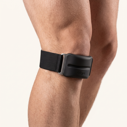 The strap worn on a knee in side profile, pad seated below the kneecap